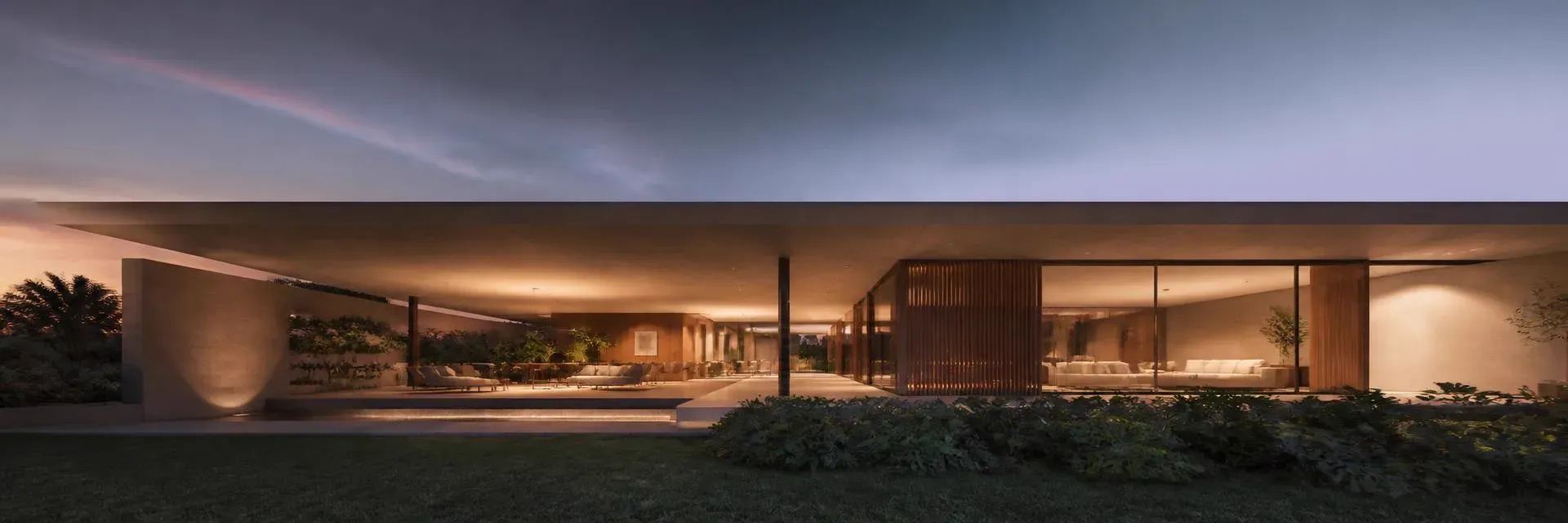 Fachada horizontal alongada de residência contemporânea ao anoitecer, com interiores iluminados